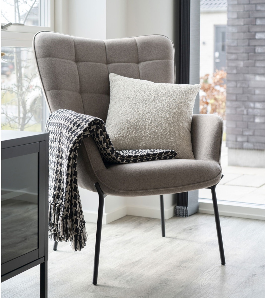 Moderner Sessel mit Kissen und Wohndecke