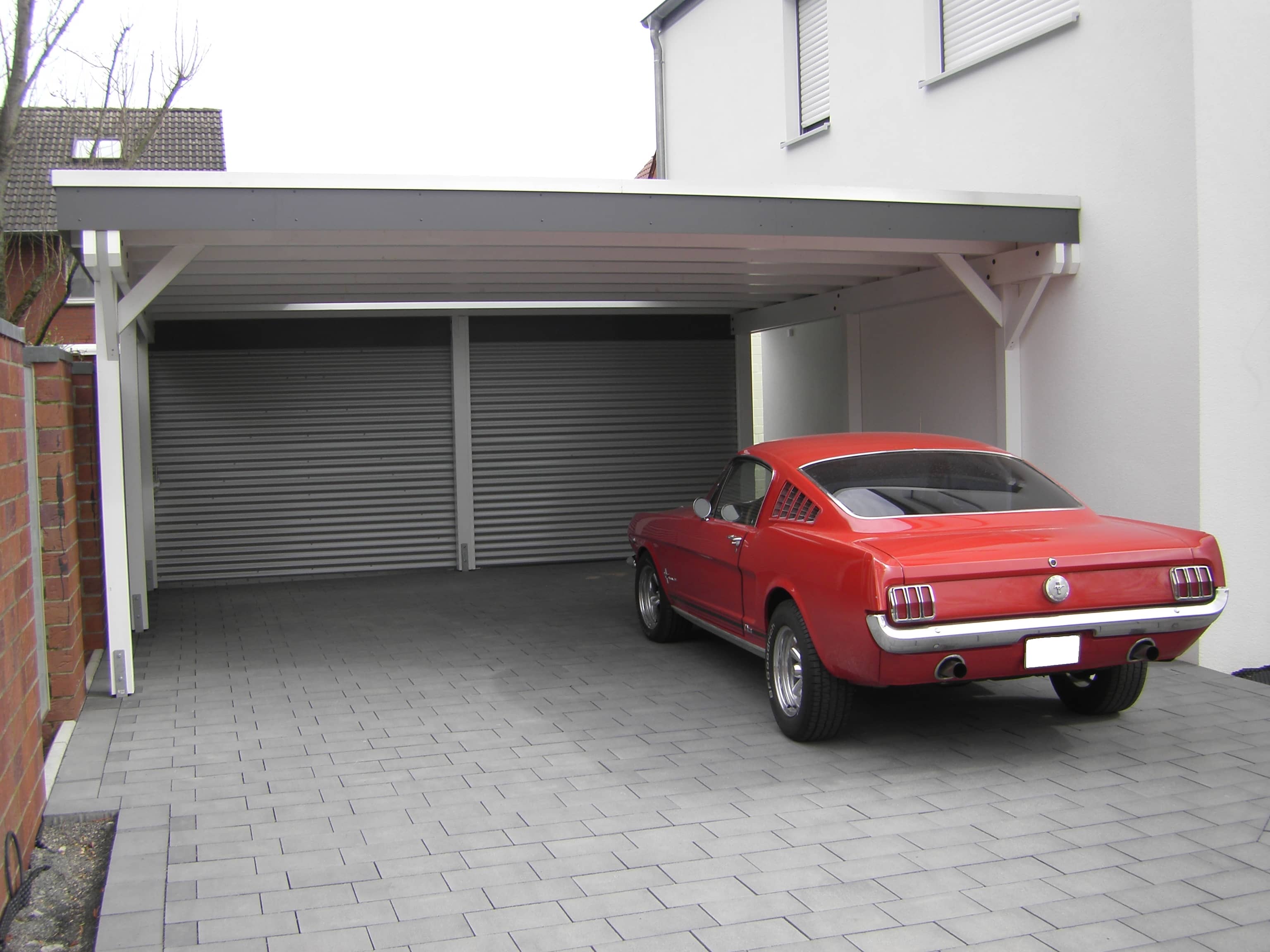 Roter Mustang Oldtimer unter modernem Carport in Weiß